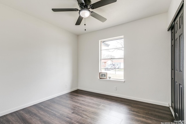 unfurnished room with dark wood finished floors, baseboards, and ceiling fan
