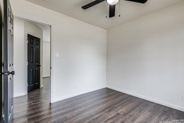 spare room with dark wood-type flooring, baseboards, and ceiling fan