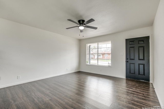 interior space featuring baseboards, dark wood-type flooring, and a ceiling fan