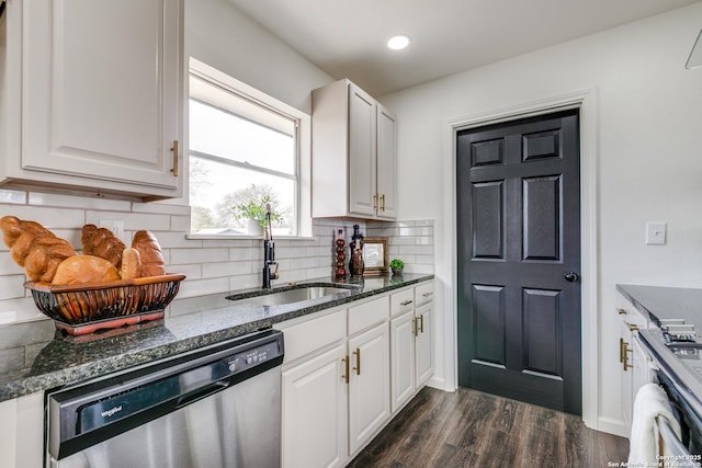 kitchen featuring dark stone counters, dark wood-style flooring, a sink, stainless steel dishwasher, and backsplash