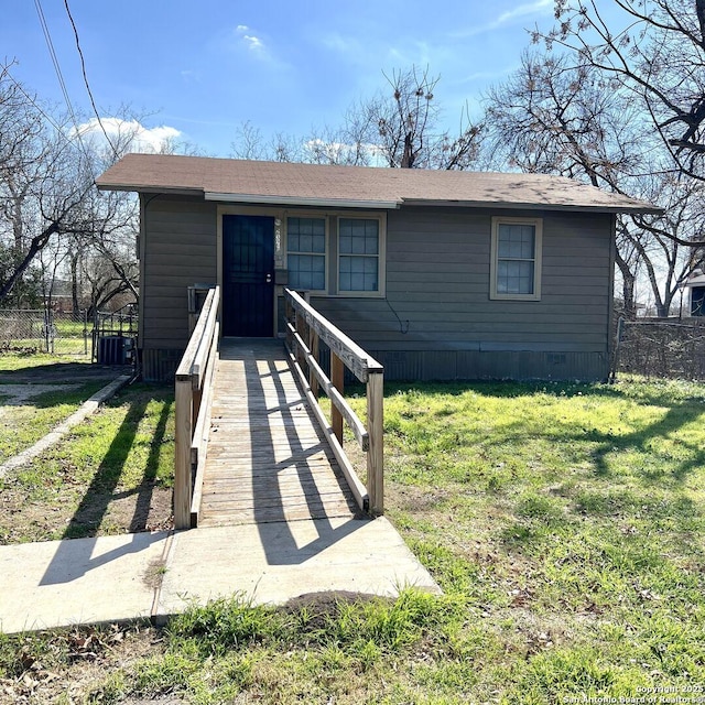 view of front facade with central air condition unit, fence, and a front yard