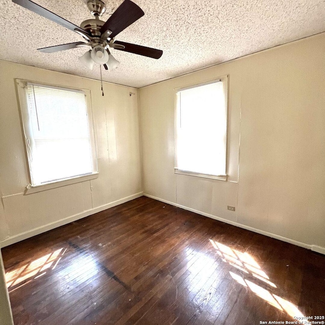 unfurnished room with hardwood / wood-style flooring, a ceiling fan, baseboards, and a textured ceiling