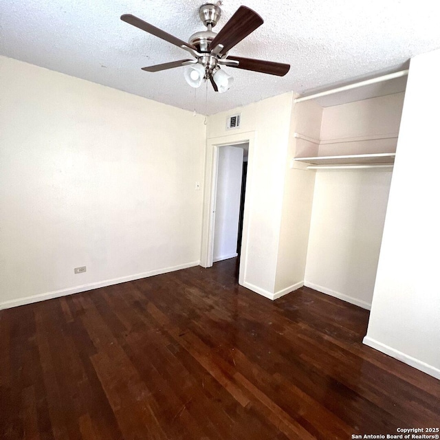 unfurnished bedroom featuring baseboards, visible vents, wood finished floors, a textured ceiling, and a closet