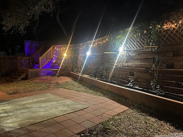 patio at night featuring fence