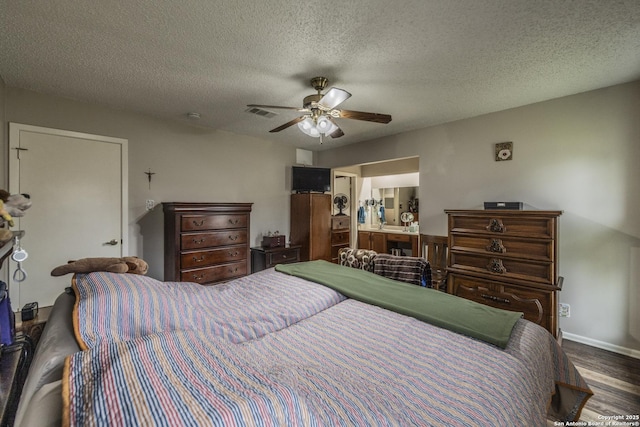 bedroom featuring a textured ceiling, visible vents, wood finished floors, and a ceiling fan