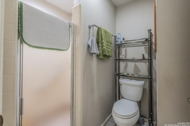 bathroom featuring a shower stall and toilet