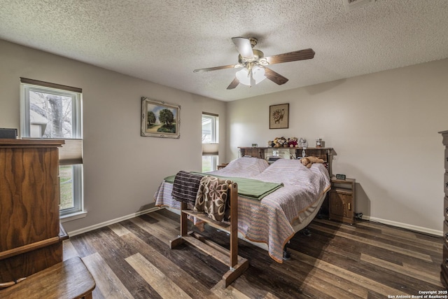 bedroom with multiple windows, wood finished floors, and baseboards