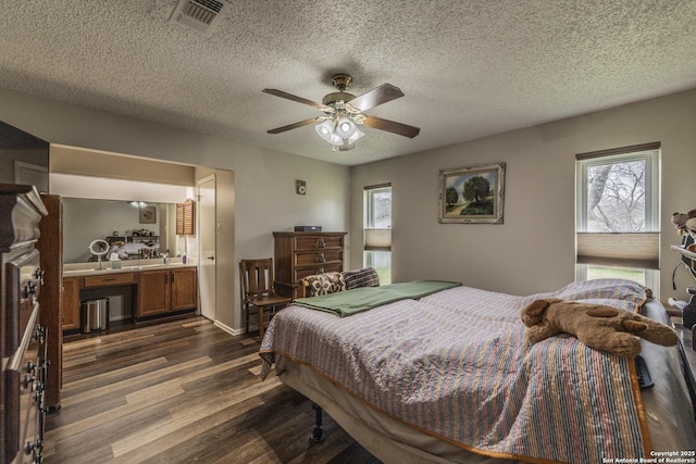 bedroom with dark wood-style floors, visible vents, and a textured ceiling