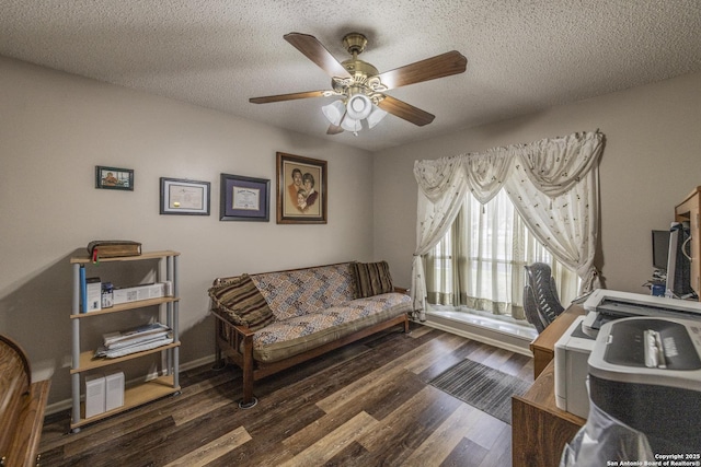 interior space featuring a ceiling fan, a textured ceiling, baseboards, and wood finished floors