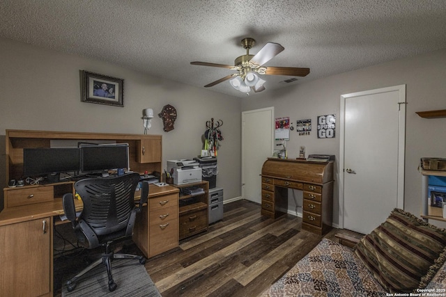 office space with a ceiling fan, a textured ceiling, visible vents, and dark wood-type flooring