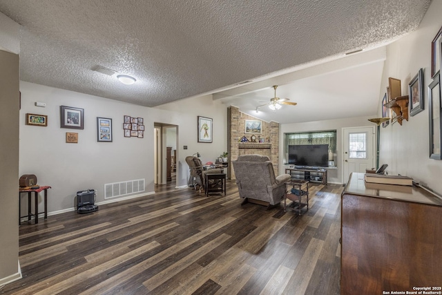 living area with visible vents, ceiling fan, dark wood-style flooring, vaulted ceiling with beams, and a textured ceiling