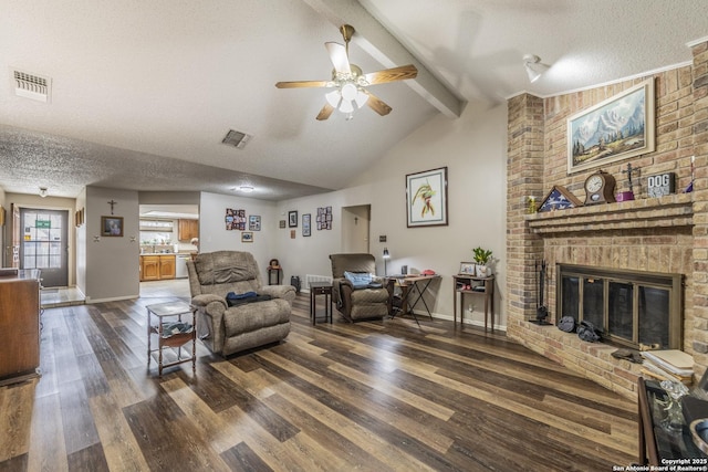 living room with a textured ceiling, beamed ceiling, and visible vents