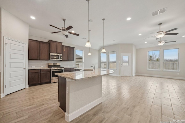 kitchen with a wealth of natural light, appliances with stainless steel finishes, backsplash, and visible vents