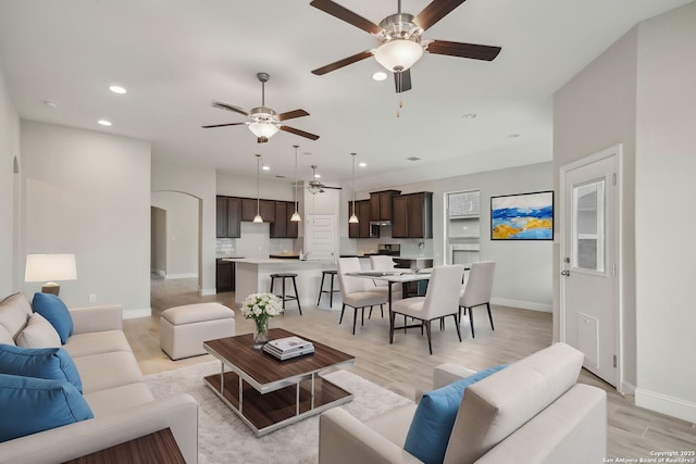 living room with light wood-type flooring, baseboards, and recessed lighting