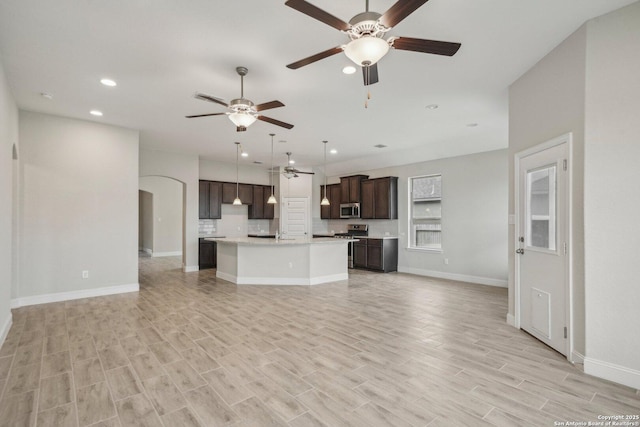 unfurnished living room with baseboards, light wood-type flooring, and recessed lighting