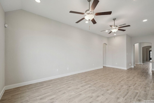 empty room featuring arched walkways, light wood-style flooring, recessed lighting, visible vents, and baseboards