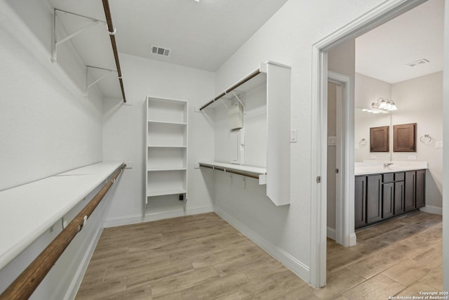 spacious closet with visible vents and light wood-style floors