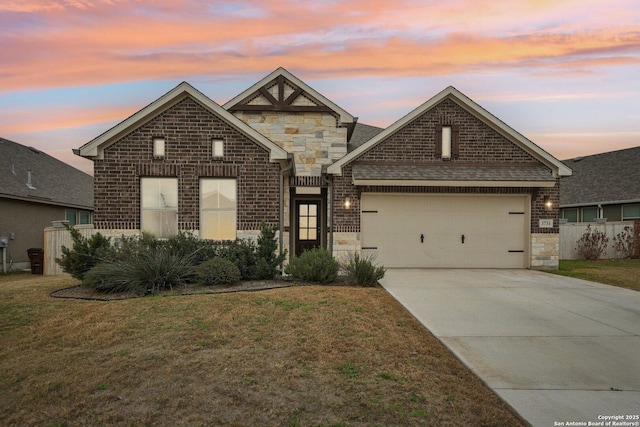 view of front of house featuring brick siding, a yard, concrete driveway, a garage, and stone siding