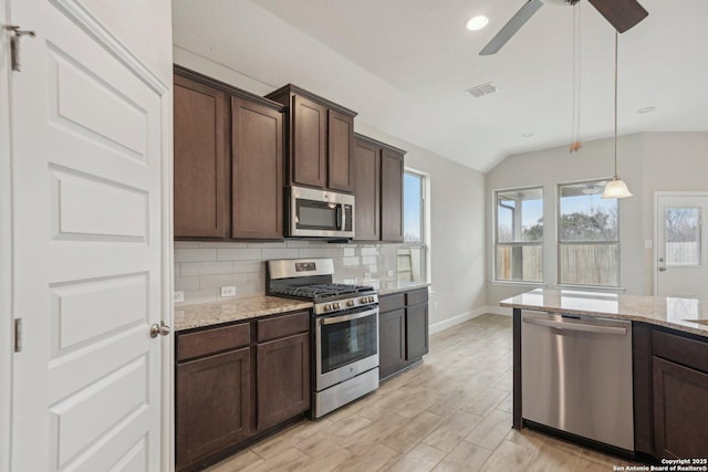 kitchen featuring visible vents, decorative backsplash, appliances with stainless steel finishes, dark brown cabinets, and light stone countertops