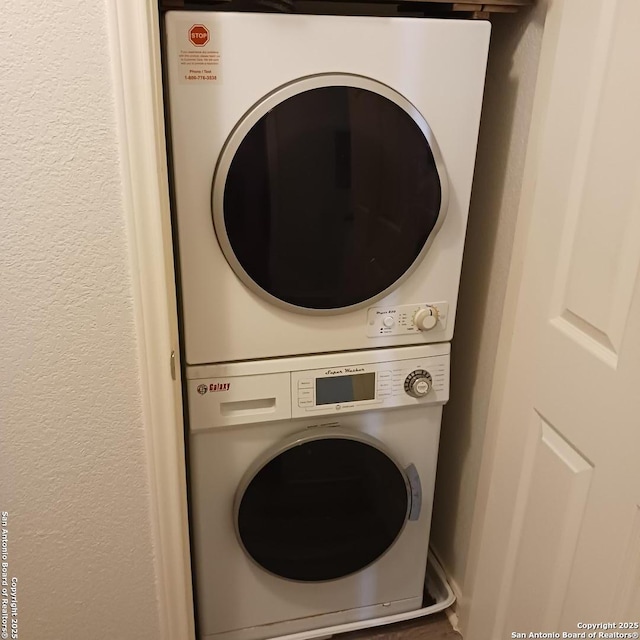 clothes washing area featuring laundry area and stacked washer / dryer