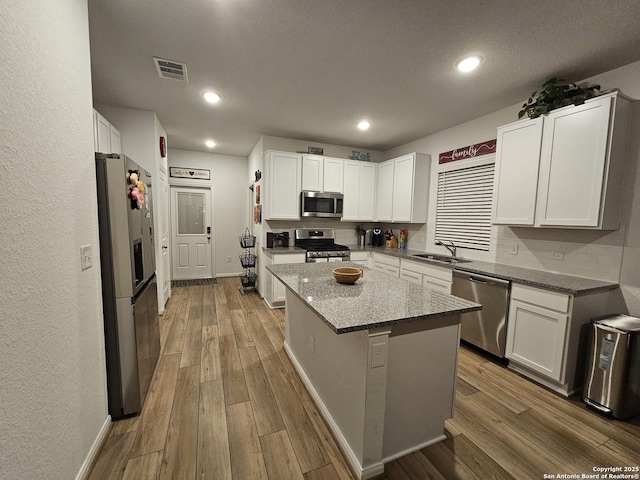 106 Tokalaun Dr, Hutto, TX 78634 - kitchen with a sink, visible vents, stainless steel appliances, and wood finished floors