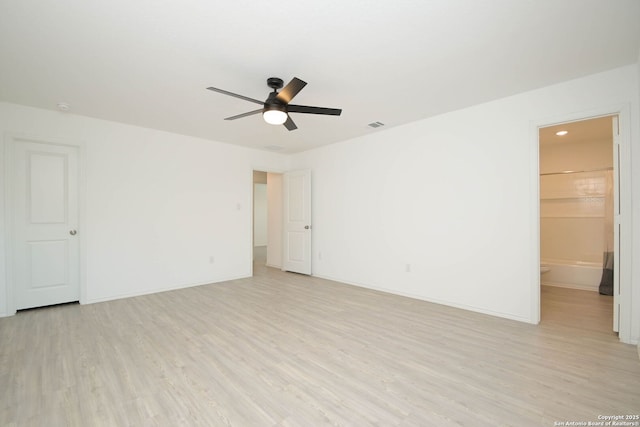 spare room with light wood-style flooring, visible vents, ceiling fan, and baseboards