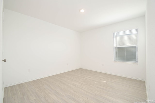 unfurnished room with light wood-type flooring and baseboards