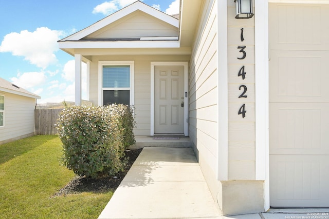 property entrance with a yard and fence