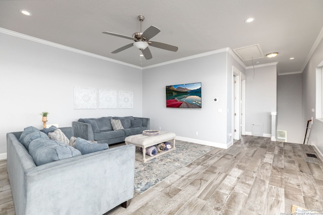 living area featuring wood finished floors, visible vents, baseboards, attic access, and crown molding