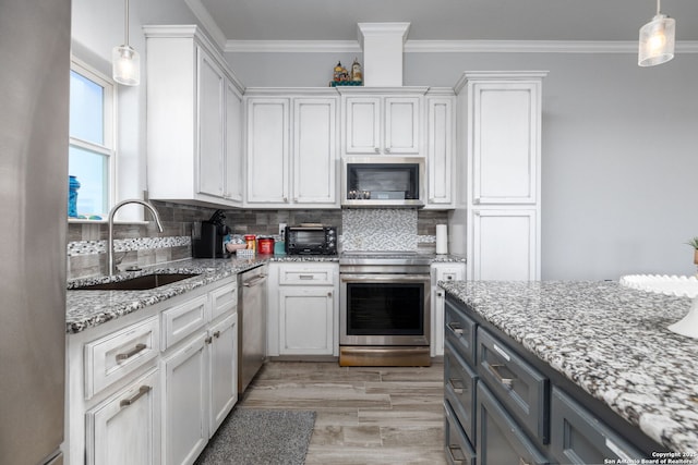 kitchen featuring appliances with stainless steel finishes, crown molding, a sink, and backsplash