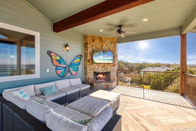 view of patio / terrace with an outdoor living space with a fireplace and ceiling fan