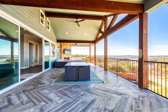 wooden terrace with an outdoor hangout area and a ceiling fan