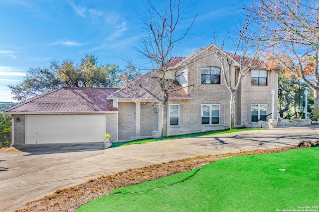 traditional-style house featuring a front lawn, brick siding, driveway, and an attached garage