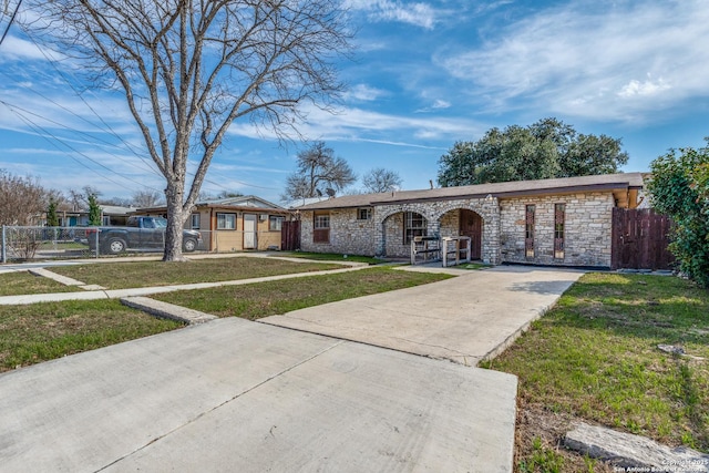 view of front facade featuring fence, a porch, concrete driveway, and a front yard