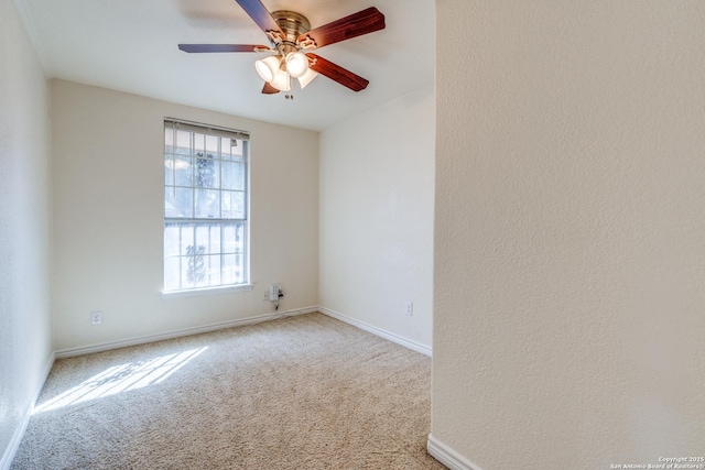 empty room with baseboards, a ceiling fan, and light colored carpet