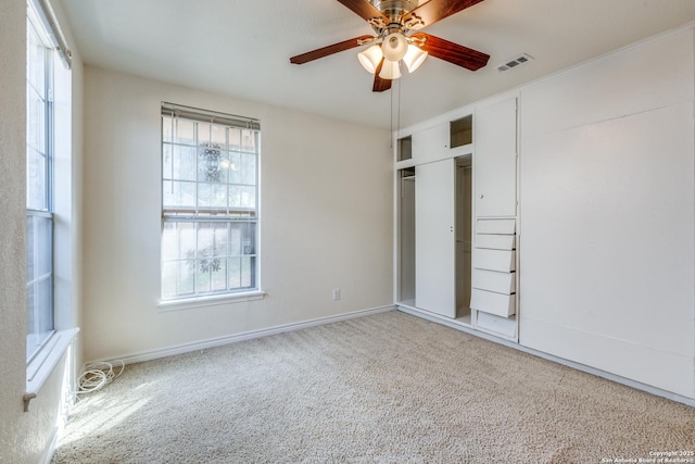 unfurnished bedroom with multiple windows, carpet, a closet, and visible vents