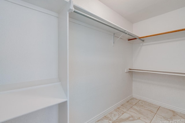 walk in closet with marble finish floor