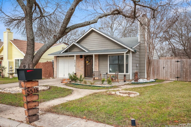 view of front of home featuring brick siding, an attached garage, a front yard, fence, and driveway