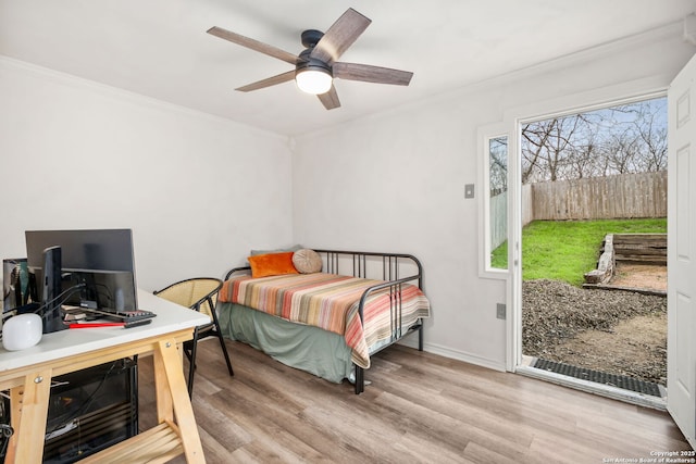 bedroom with baseboards, access to outside, ornamental molding, and wood finished floors