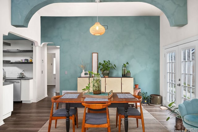 dining space featuring a wealth of natural light, a high ceiling, wood finished floors, and french doors