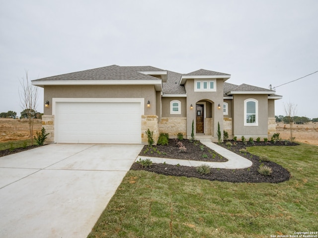 prairie-style home featuring a garage, concrete driveway, stone siding, stucco siding, and a front yard