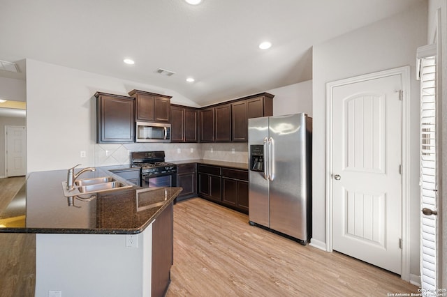 kitchen featuring light wood finished floors, tasteful backsplash, appliances with stainless steel finishes, a sink, and dark brown cabinetry