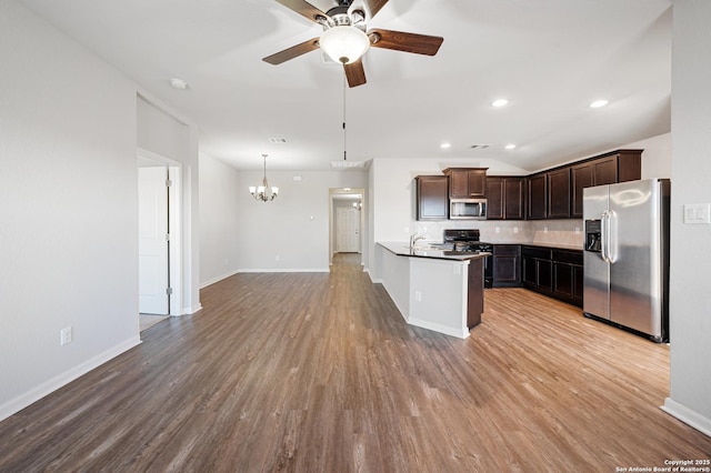 kitchen with dark brown cabinetry, a sink, appliances with stainless steel finishes, light wood-type flooring, and decorative backsplash