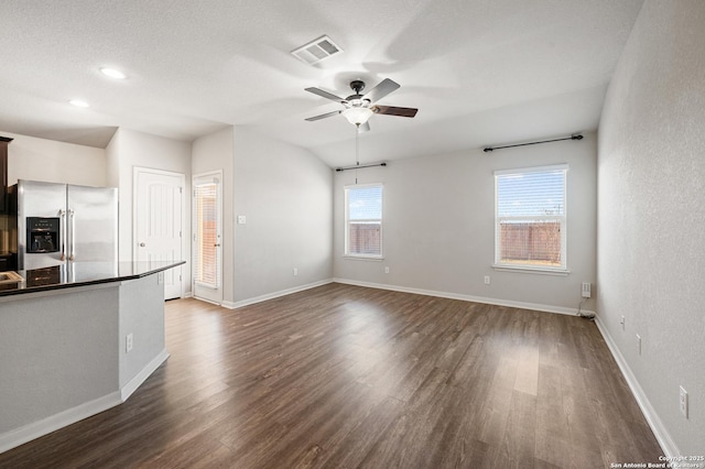 kitchen featuring visible vents, dark wood finished floors, stainless steel fridge with ice dispenser, dark countertops, and ceiling fan