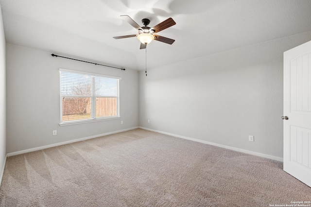 empty room featuring a ceiling fan, light carpet, and baseboards