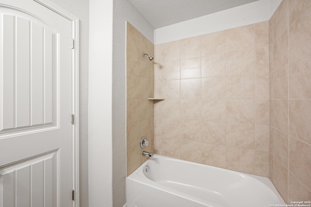 full bathroom featuring bathtub / shower combination, a textured ceiling, and a textured wall