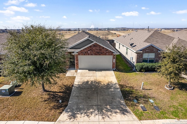 view of front of home featuring an attached garage, a front yard, concrete driveway, and brick siding