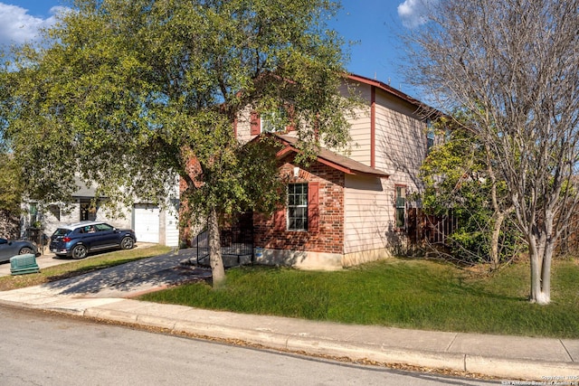 view of front of home featuring a garage, driveway, brick siding, and a front yard