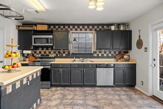 kitchen featuring a sink, visible vents, light countertops, appliances with stainless steel finishes, and tasteful backsplash