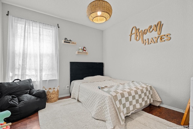 bedroom with baseboards and wood finished floors